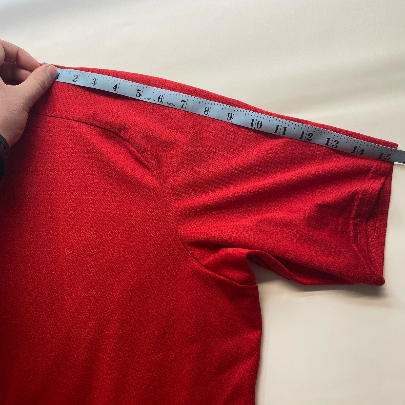 Red mesh Izumi men’s cycle shirt, small size, with front half-zip closure, made in Taiwan, measured on a light gray surface.