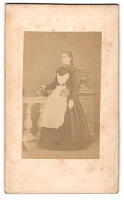 Photograph young woman as waitress pouring wine into a glass 