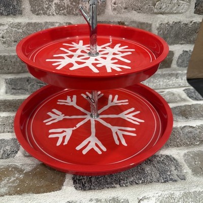 two-tiered red metal serving stand with white snowflake designs