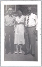 Vtg B&W Snapshot Two Men And Woman in Gingham Dress Brick Wall Backdrop Aug 1958