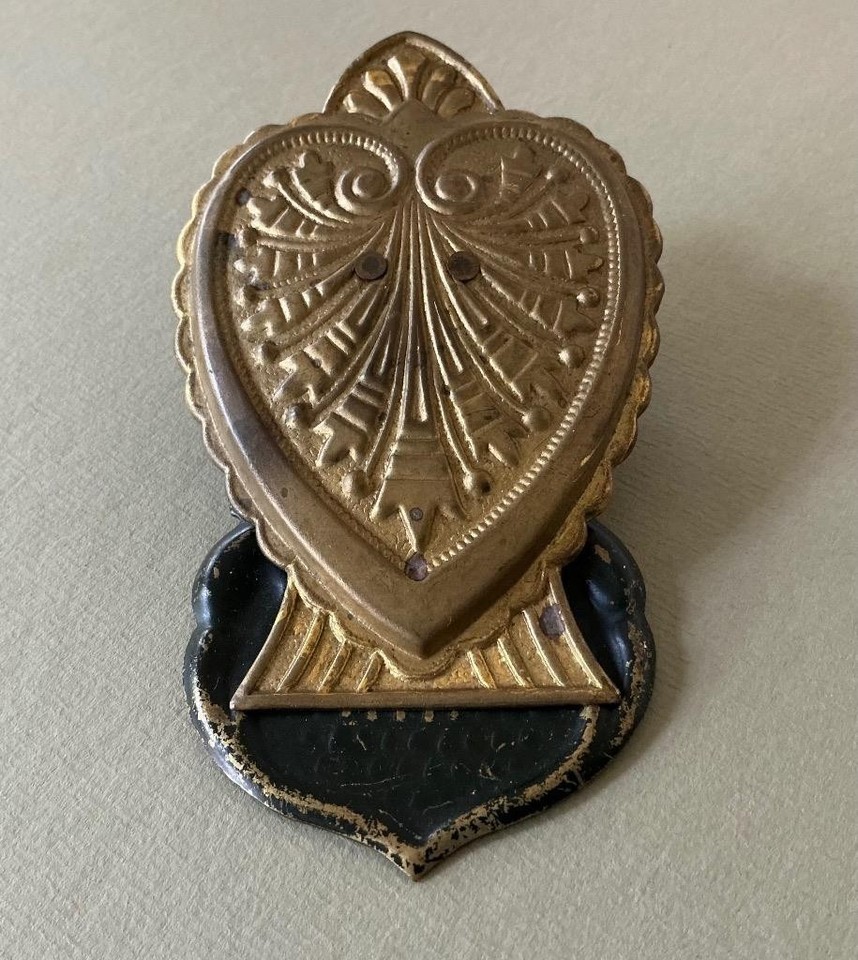 An 1880s stamped brass paper clip designed for desk or wall — an absurdly charming Victorian office artifact that doubles as sculptural decor.