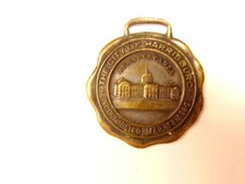 old heavily worn Harrisburg, PA watch fob showing the State Capitol building