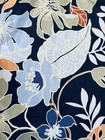 Navy blue Hawaiian shirt with white floral print, green leaves, and orange accents on a wood surface.