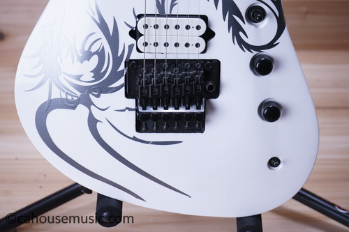 White Jackson Pro Series Soloist 6 with black/silver dragon-scale design, five pickups, and gold hardware.