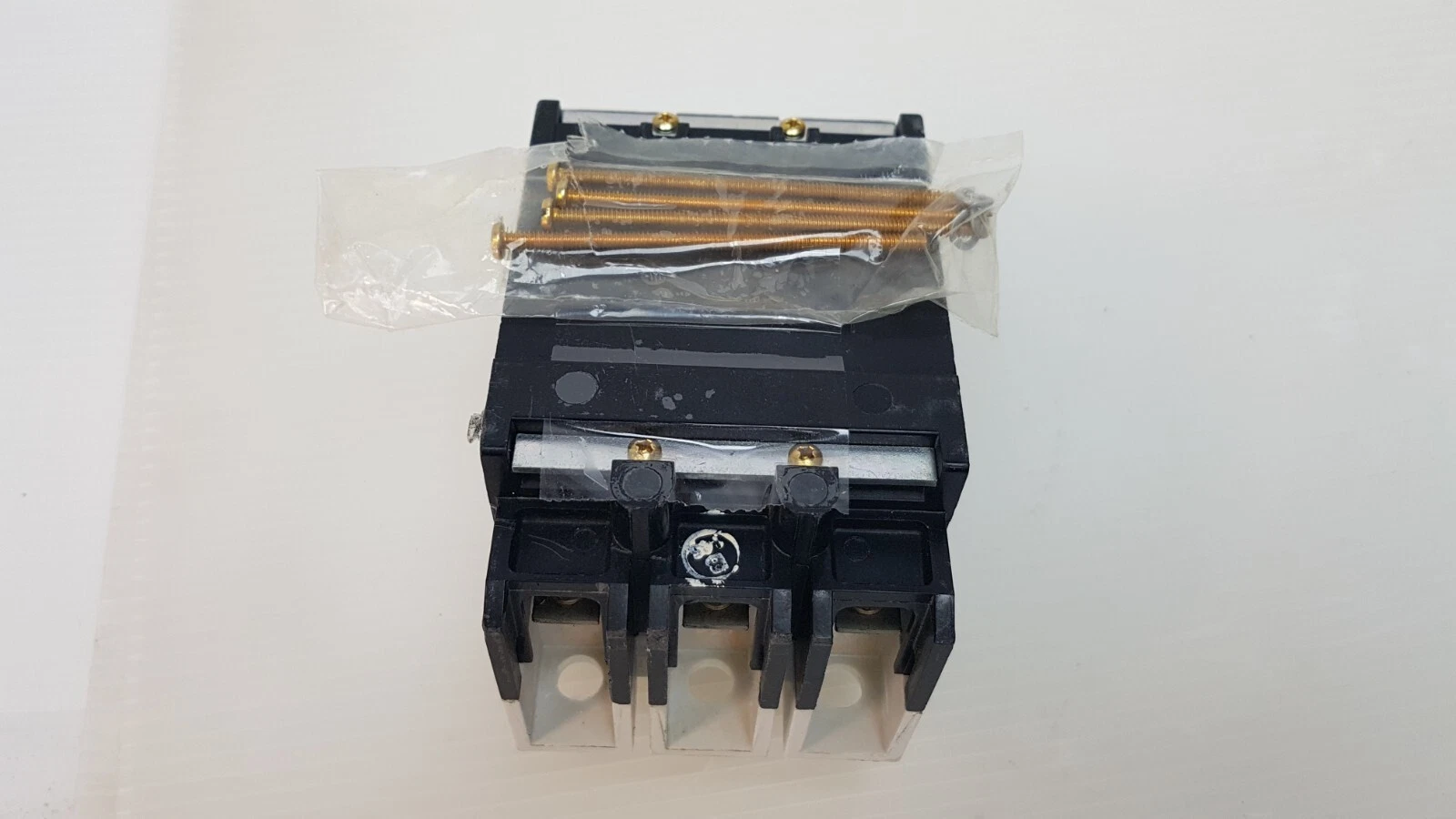 Back of the Eaton GD-D breaker with taped bag of brass screws