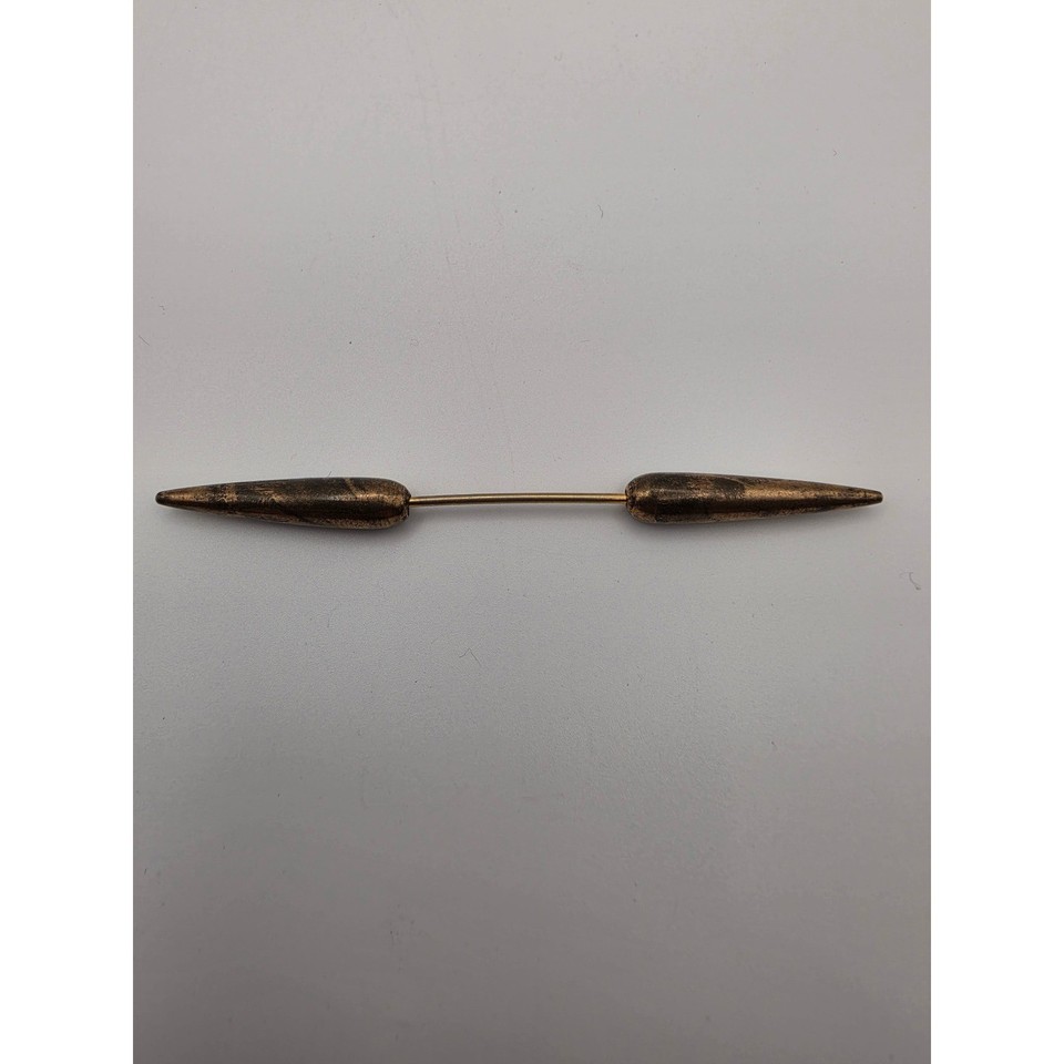 A torpedo/bullet-shaped screw-on collar bar in aged bronze — a wildly distinctive men's dress accessory that almost no one has seen before.