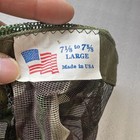 Close-up of Vtg Camo hunting mosquito net facemask with green and red camo pattern and white fabric label reading “7½ to 75% LARGE MADE IN USA.”
