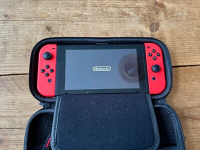 Gebrauchte Nintendo Switch Konsole mit roten Joy-Con Controllern. mit Koffer