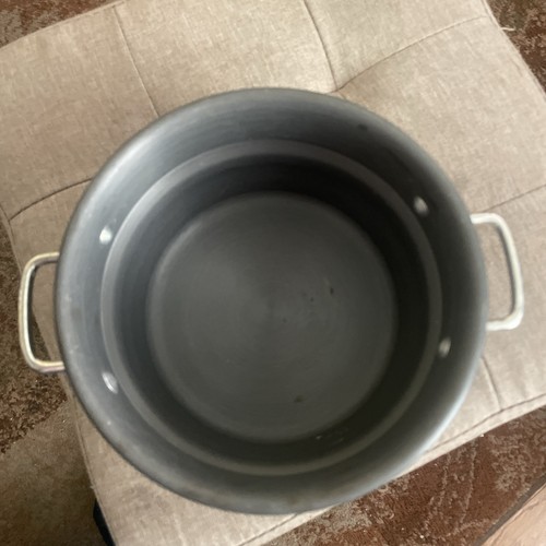 Black Calphalon 2.5 quart double boiler insert with white handles, shown from above on a light gray upholstered surface.