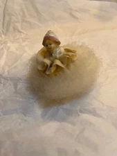 Small girl Sitting on a Swan Down Powder Puff