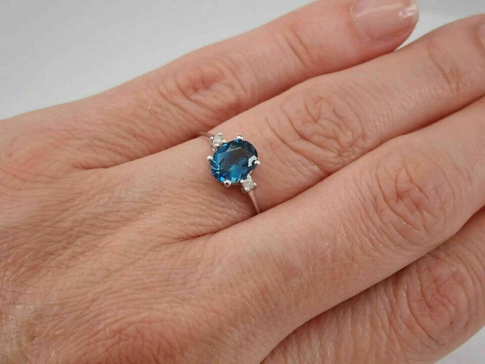 Anillo de compromiso de tres piedras con topacio azul corte ovalado de 2 quilates acabado en oro blanco de 14 quilates Foto 4 de 4