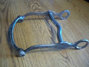 CROCKETT STAINLESS CURB BIT W/ ENGRAVED SILVER OVERLAY ON CHEEKS AND LIP BAR.