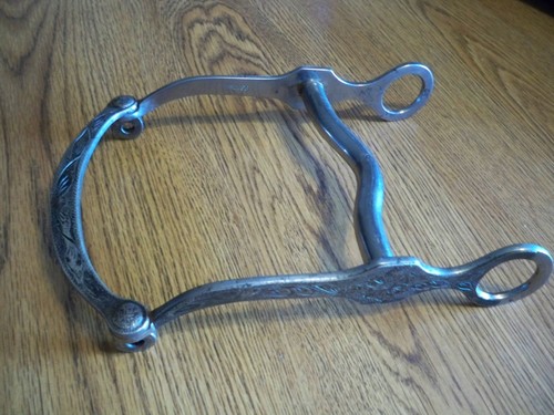 CROCKETT STAINLESS CURB BIT W/ ENGRAVED SILVER OVERLAY ON CHEEKS AND LIP BAR.