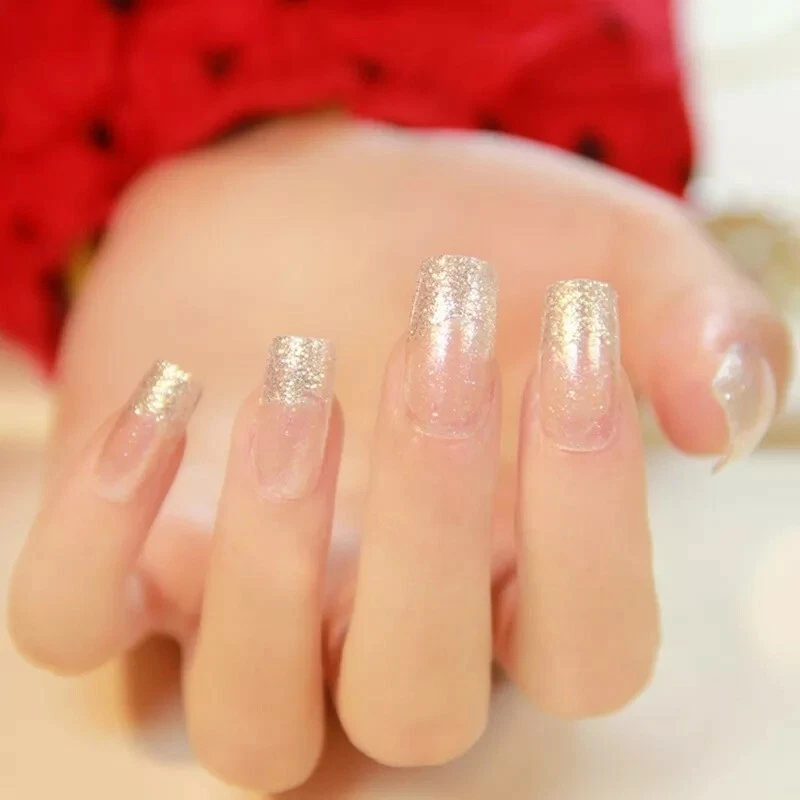 Golden nail art manicure. Holiday style bright manicure with gems and  sparkles. Bottle of nail Polish. Fashion rings Stock Photo