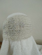 KNITTED HEADBAND WITH ADJUSTABLE BUTTON CLOSURE.
