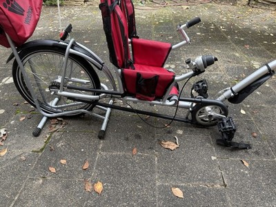 Weehoo IGO Turbo Kinderfahrrad Anhänger In Rot, mit einem Fahrradständer.