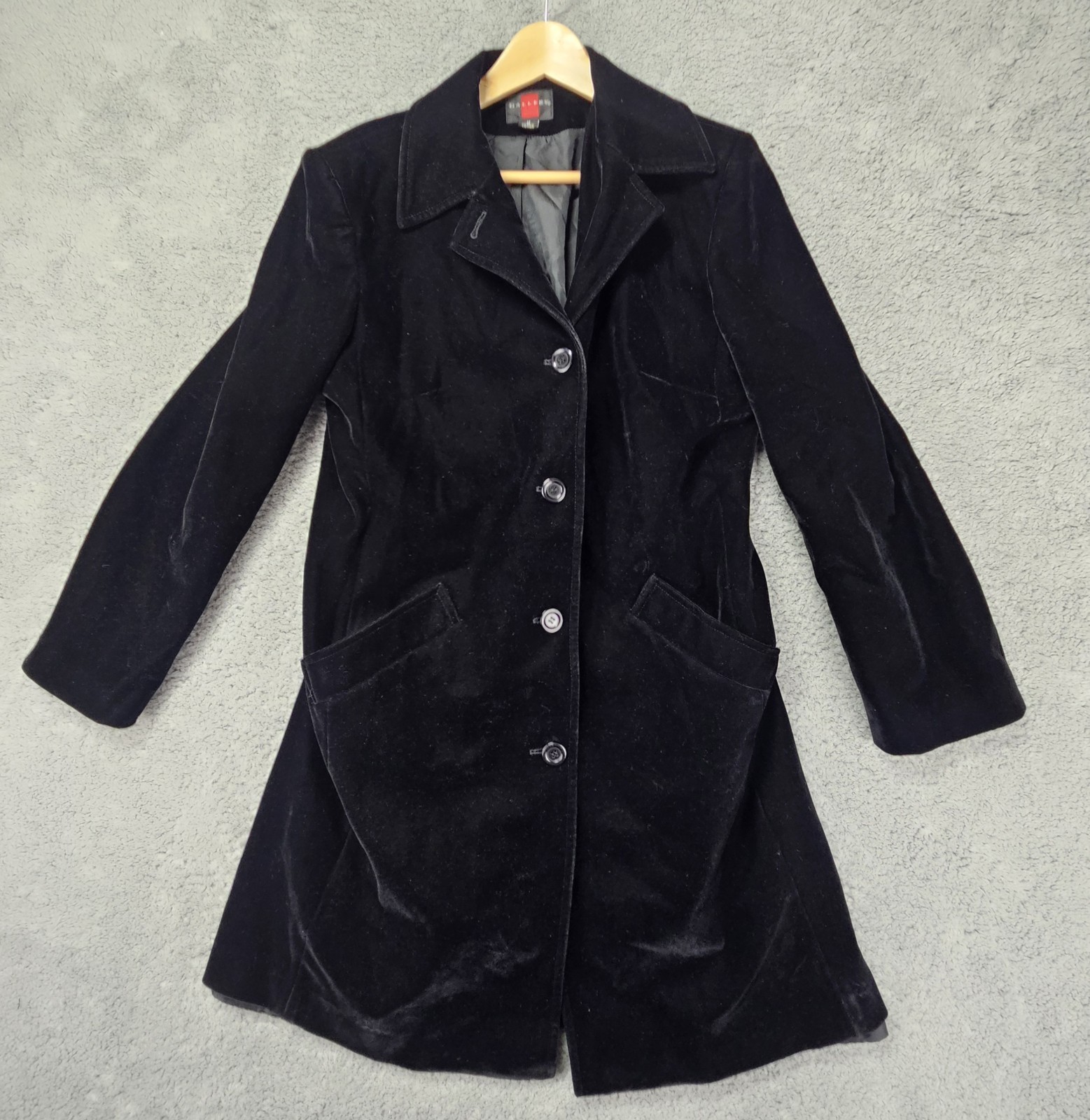 Black velvet single-breasted blazer coat on a hanger