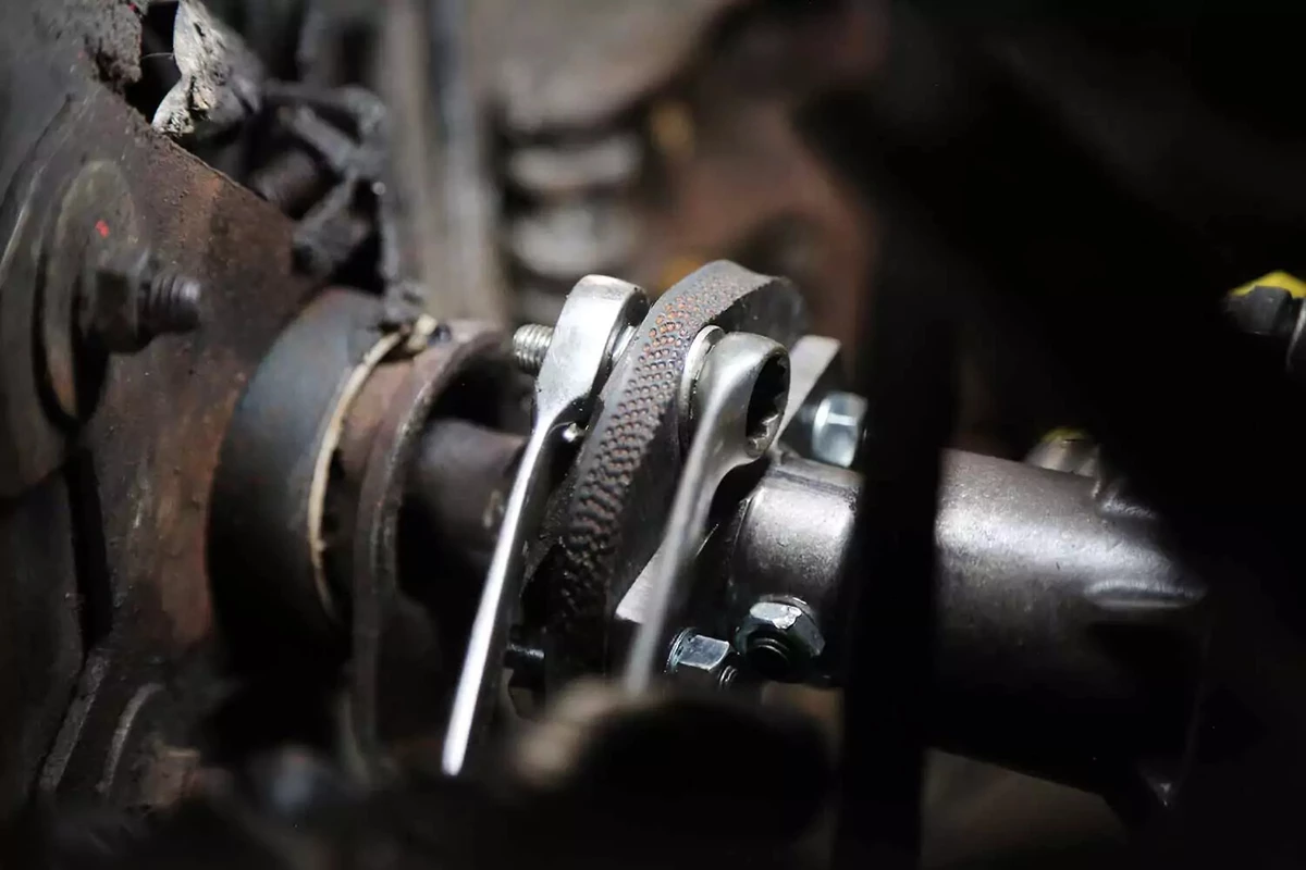 A pair of wrenches tighten a rag joint bolt.