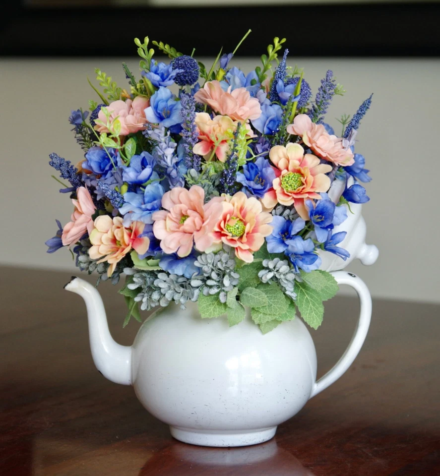 Tetera vintage esmaltada blanca con margaritas melocotón con delfinio azul, flores silvestres Foto 3 de 4