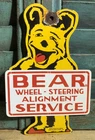 VINTAGE 1955 DATED BEAR WHEEL ALIGNMENT 8” PORCELAIN SIGN GAS OIL SERVICE