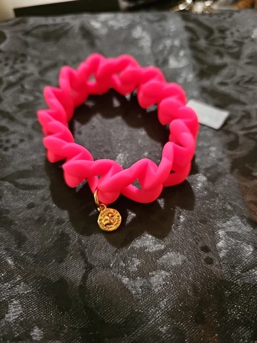 Bracciale Michael Kors Knockout in gomma rosa elasticizzato con ciondolo oro