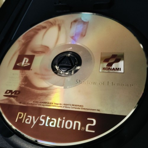 PS2 Shadow of Memories Konami disc with gold background, partial woman figure, and PlayStation2 logo.