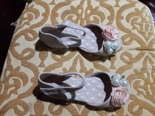 Girl's decorative sandals with pearls and flowers embellishments.