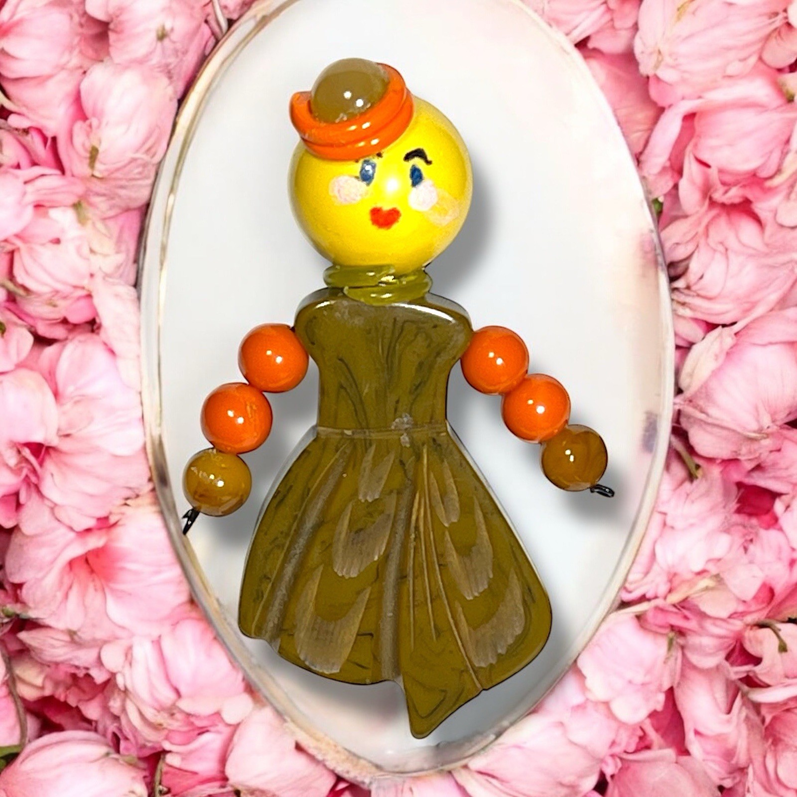 PONY Spilla figurativa in bachelite ragazza con cappello arancione e abito verde stile culla giocattolo