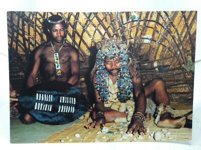 Ein Sangoma Hexendoktor bereitet sich darauf vor, die Zukunft eines Stammesangehörigen zu lesen Vintage Postkarte