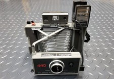 VINTAGE POLAROID 440 WITH ATTACHED FLASH HOLDER