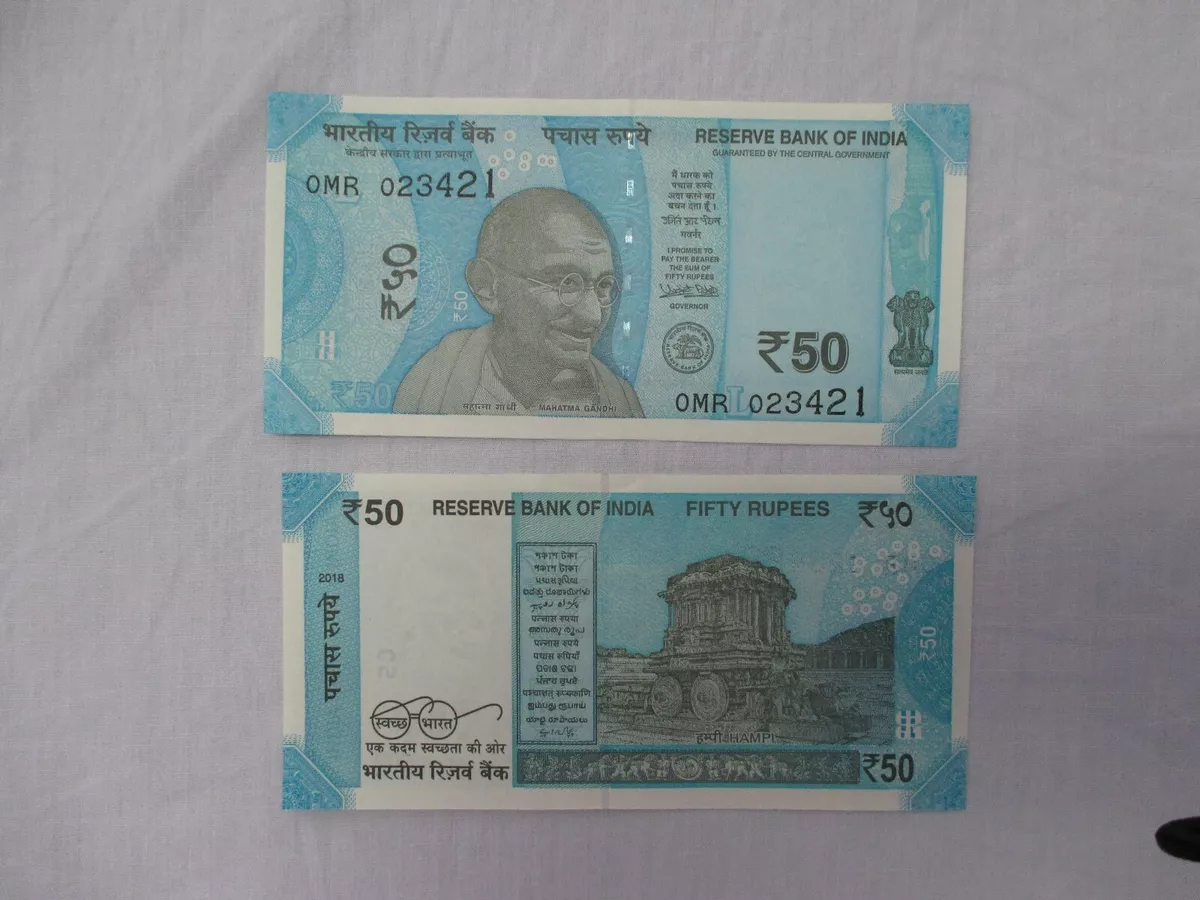 50000 Indian rupees banknote lying on top of 1 US dollar bills