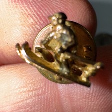 Skier pin in gold-colored metal
