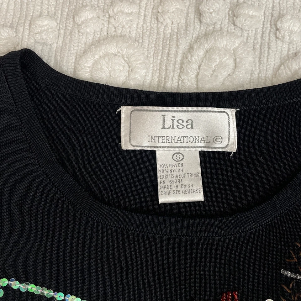 Top navideño Lisa International adornado con lentejuelas negras, pequeño para mujer, de colección Foto 2 de 4
