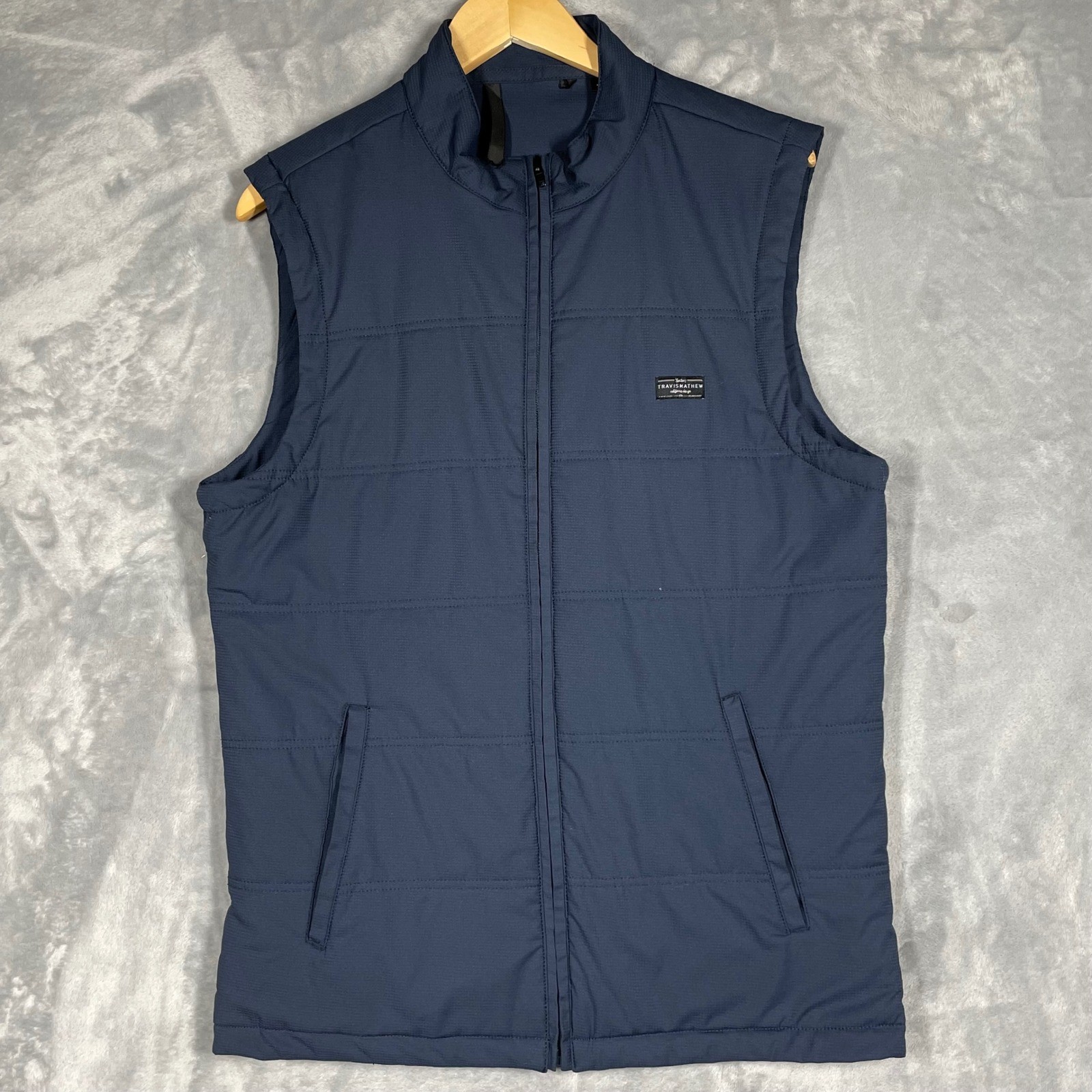 Chaleco de golf TravisMathew para hombre azul marino acolchado cremallera completa cuello falso talla mediana
