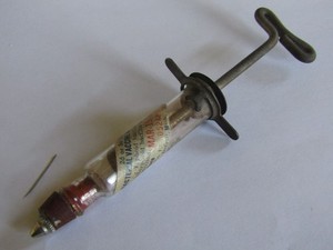 antique glass syringe with typhoid vaccine sticker on empty vial  1931
