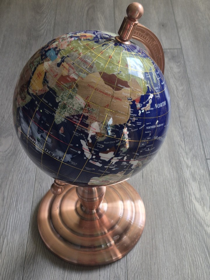 A 16" globe with actual gemstone inlays and a brass stand — functional art that doubles as a serious conversation piece.