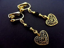 A PAIR OF GOLD COLOUR DANGLY HEART  CLIP ON EARRINGS. NEW.