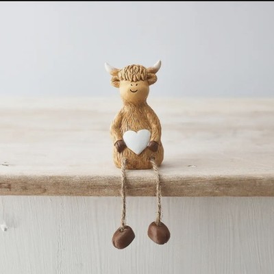 Highland Kuh sitzend Ornament mit Herz Detail. Schlenkende Bein Kuh Figur.