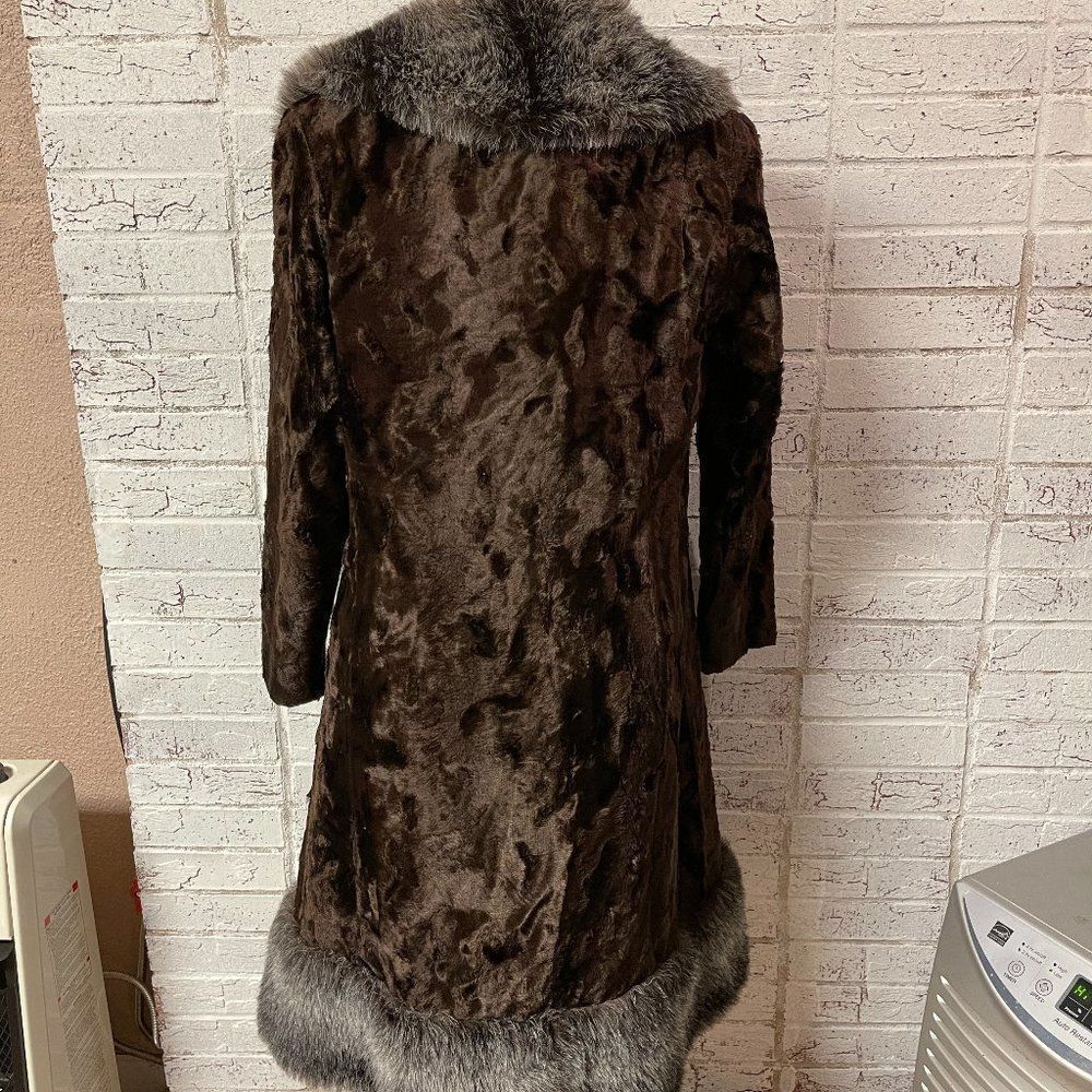 Brown vintage ILGWU winter coat with high collar and textured fur lining, made in USA, hanging on a white wall hook.