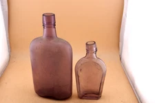 TWO VINTAGE AMETHYST SUN COLORED BOTTLES