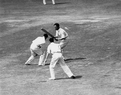Denis Compton of England swings round to hit a ball from Mann duri- Old Photo