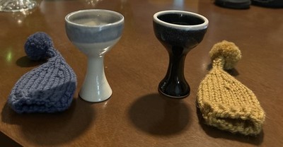 Edd cups, each with a knitted egg cozy on top.