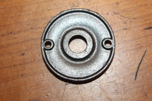 Round antique cast iron doorknob escutcheons with smooth center and brushed texture on the flat metal plate.