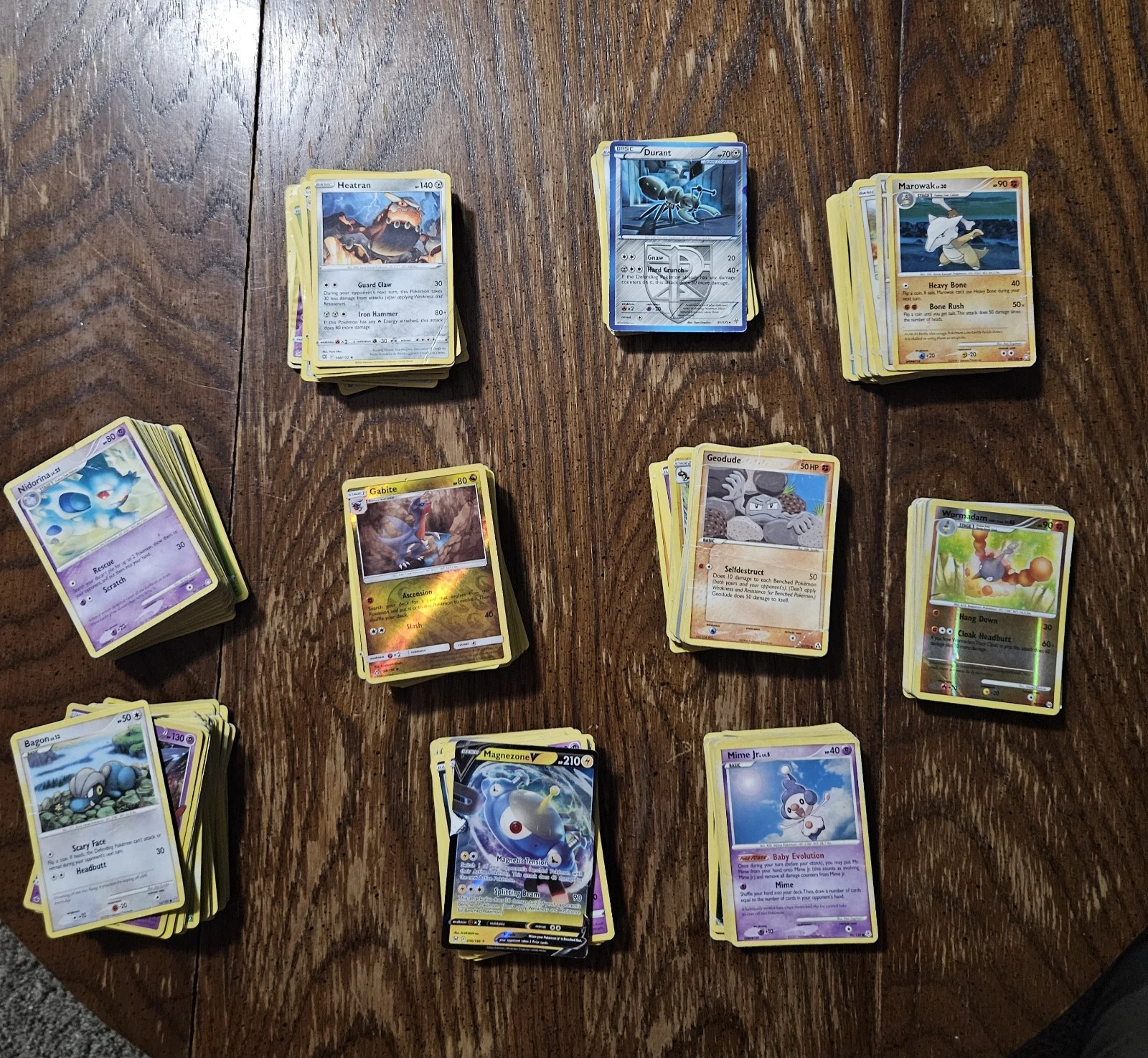 Piles of Pokemon cards on a wooden table