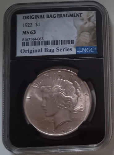 1922 $1 NGC MS63 WITH ORIGINAL BAG FRAGMENT IN SLAB