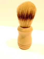 older unmarked shaving brush with a tan colored molded plastic handle