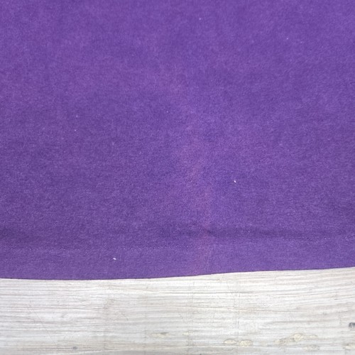 Purple vintage ATLANTA GEORGIA T-shirt with single stitch, white cuff, and wooden base on a light surface.