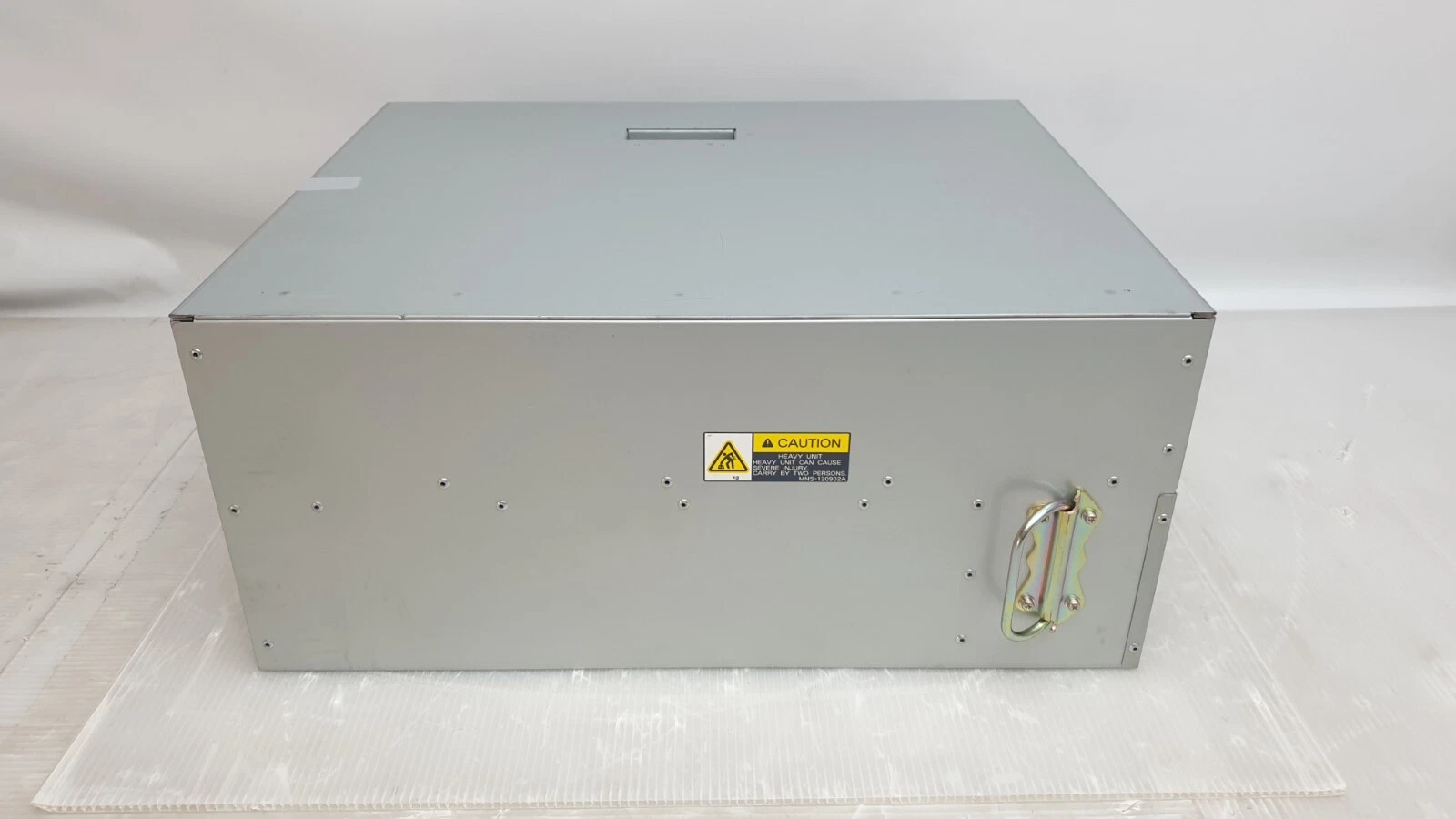 Side of the PFU computer with carry handle and heavy unit caution label