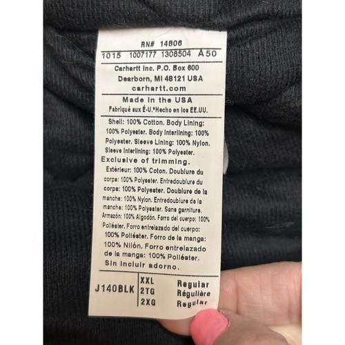 Black Carhartt men’s hooded jacket size 2XL with 14806 RN#, white printed specifications, and “Made in the USA” label.