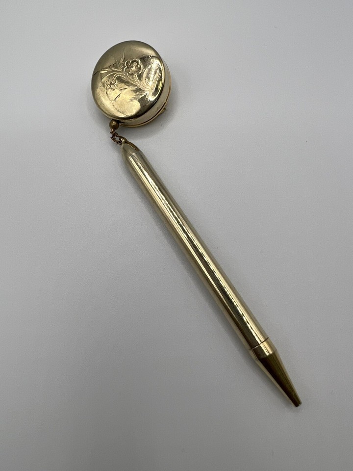 A wearable 1960s gold-plated mechanical pencil that doubles as a brooch — functional vintage jewelry that's equal parts desk accessory and conversation starter.